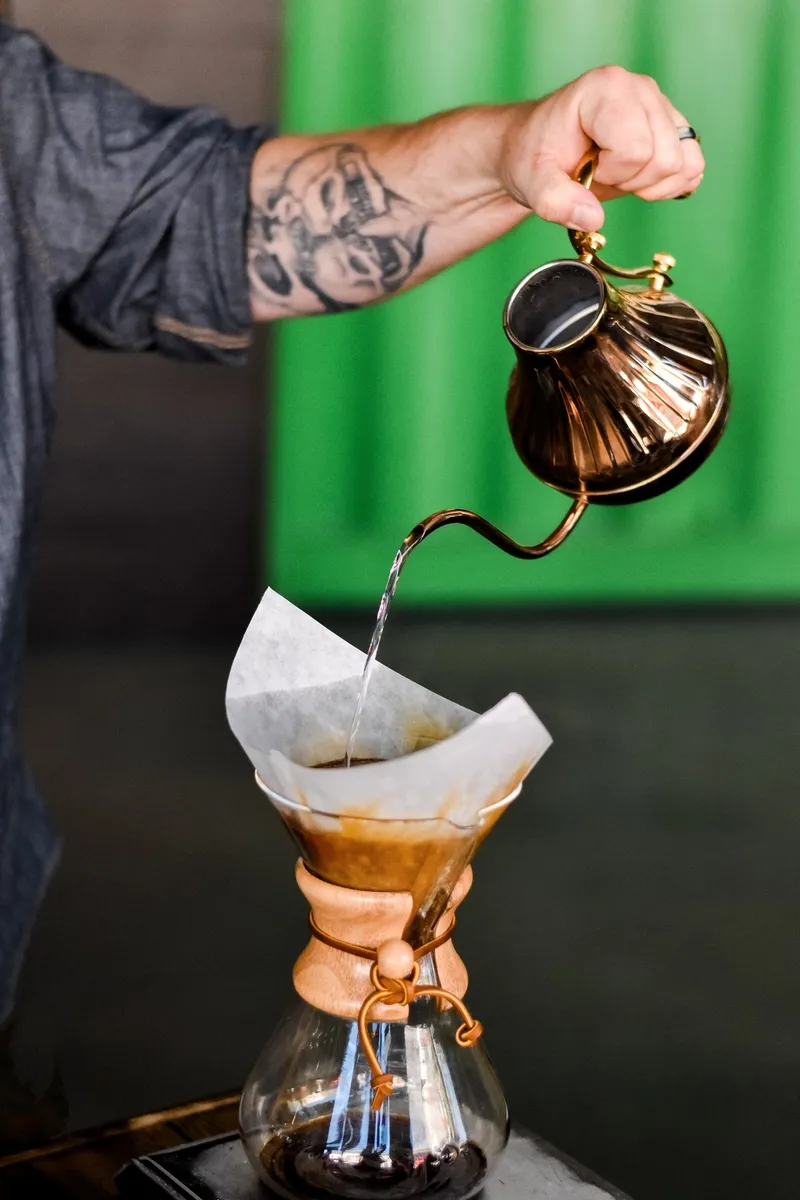 O mână de barista prepară cafea metoda V60